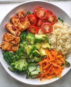 a white bowl filled with rice, broccoli, carrots and tofu