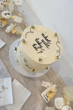 a white cake sitting on top of a table covered in honeycombs and bees