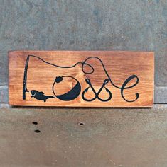 a wooden sign with the word love and two birds on it, hanging from a wall