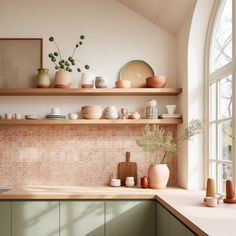 a kitchen with shelves filled with dishes and vases on top of the countertop