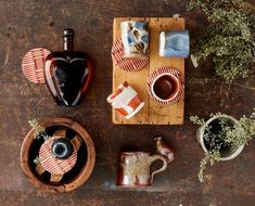 an assortment of coffee cups and saucers on a wooden tray