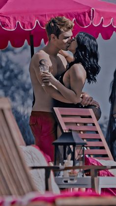 a man and woman kissing under an umbrella