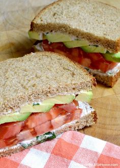 two halves of a sandwich with tomatoes, avocado and tomato slices on it