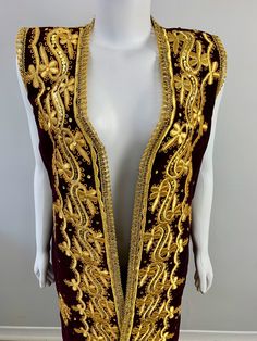 a white mannequin wearing a gold and burgundy dress