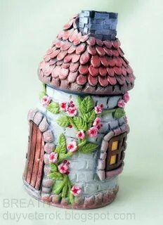 a ceramic house with pink flowers and green leaves