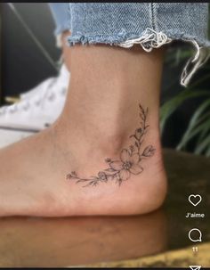 a woman's foot with a small flower tattoo on the side of her ankle