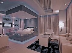 a large bedroom with white furniture and lights