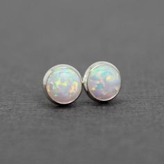 These opal stud earrings are beautiful.  They feature a single 6mm simulated opal cabochons.  Hand bezel set in my studio.  6mm Simulated Opal Round CabochonsSolid 925 Sterling Silver or 14/20 Gold FilledArtisan Made in TexasArrives thoughtfully packaged in a signature jewelry boxCheck out all of my opal earrings: https://www.etsy.com/shop/KMBankston/search?search_query=opal+earring&order=date_desc&view_type=gallery&ref=shop_search~About Me:My name is Kathy Bankston, and I am a metal Minimalist Iridescent Round Jewelry, Hypoallergenic Round Opal Jewelry, Minimalist Ethiopian Opal Round Jewelry, Dainty Round Ethiopian Opal Jewelry, Classic Opal Jewelry As A Gift, Classic Opal Jewelry For Gifts, Dainty Ethiopian Opal Round Jewelry, Classic Opal Cabochon Jewelry, Classic Opal Birthstone Jewelry