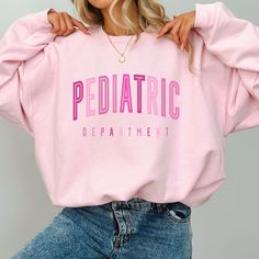 This Pediatrics Nurse Sweatshirt / PEDS Department Crewneck Sweater is so PINK and warm and cozy - perfect for those chilly days in the PEDS unit!   **UNISEX SIZING**  See more of our Pediatrics Merch here!:  https://www.etsy.com/shop/SketchyCatDesigns?search_query=pediatric    ♥ W E L C O M E  T O  S K E T C H Y  C A T  D E S I G N S ! ♥ Click here to return to our shop's home page ⇒ https://www.etsy.com/shop/SketchyCatDesigns Say hello to your new favorite sweatshirt! All of our products are p Picu Nurse Sweatshirt, Pediatric Nurse Shirts, Pediatric Doctor, Peds Nurse, Midwife Gift, Pediatric Nurse, Future Nurse, Nicu Nurse, Nurse Sweatshirt