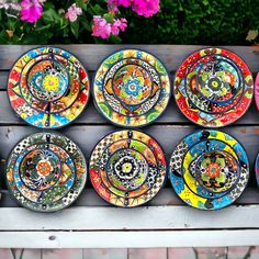 colorful plates are arranged on a wooden bench