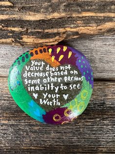 a painted rock with a quote on it