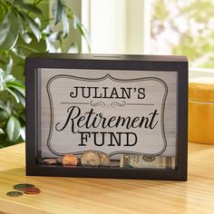 a wooden sign that says julian's retirement fund on top of a table next to money