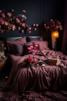 a bed covered in purple sheets and pillows with flowers on the headboard next to it