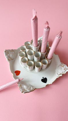 there are many pink candles in the cup on the plate with it's holder