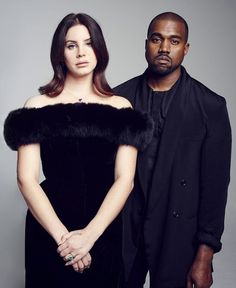 two people standing next to each other in front of a gray background with one person wearing a black dress