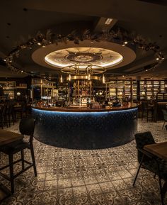 a dimly lit bar in the middle of a room filled with tables and stools