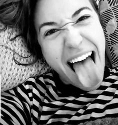 a woman laying down with her tongue out