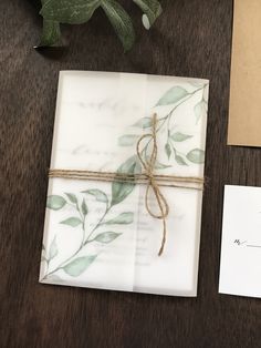 a table topped with two envelopes covered in paper next to a potted plant