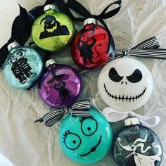 some ornaments are sitting on a sheet of paper and have been painted to look like halloween characters