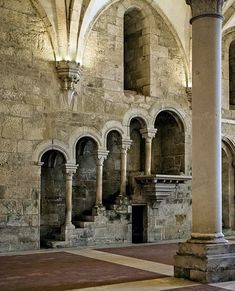 the interior of an old building with stone columns and arches on either side of it