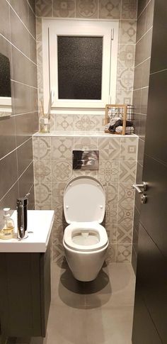 a white toilet sitting in a bathroom next to a sink