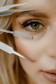 a close up of a woman with scissors on her face and hair in front of her eyes