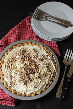 a pie sitting on top of a metal pan next to a fork and plate with utensils