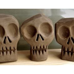 three clay skulls sitting next to each other