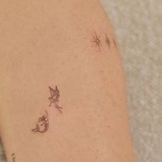 a small tattoo on the back of a woman's left arm, with two little birds