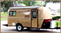 an old camper trailer is parked on the street