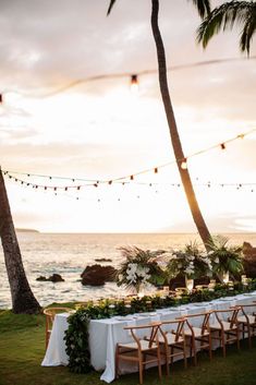 a long table set up for an outdoor dinner by the ocean