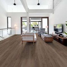 a living room filled with furniture and a flat screen tv on top of a wooden floor