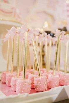 pink and gold desserts are arranged on a tray