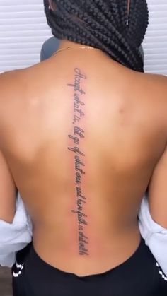 the back of a woman's body with writing on her upper and lower back