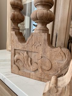 an ornate wooden frame on top of a white marble counter with a mirror in the background