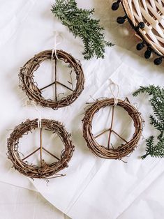 three wreaths made out of twigs and twine tied to each other on top of a table