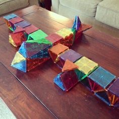 a wooden table topped with lots of colorful pieces of glass on top of it's surface