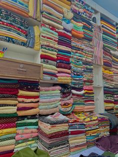 many different colored fabrics on display in a store