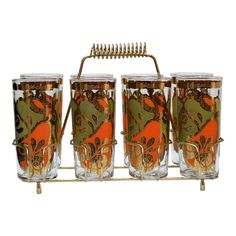 four glasses are sitting on a rack with a hair comb in the middle of them