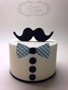 a white cake with a blue bow tie and a black mustache