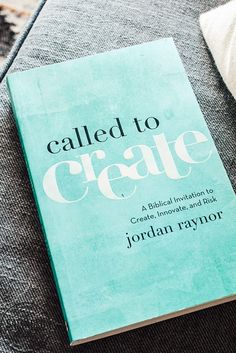 a book sitting on top of a couch next to a white and black pillow with the title called to create