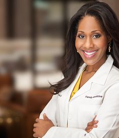 a woman in a white lab coat is posing for a photo with her arms crossed