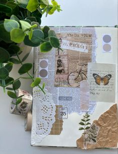 an open book with papers and stickers on it next to a potted plant