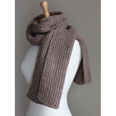 a white mannequin wearing a brown knitted scarf