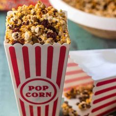 popcorn in a striped red and white paper cup with the word pop corn on it