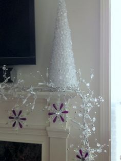 a white christmas tree sitting on top of a mantel