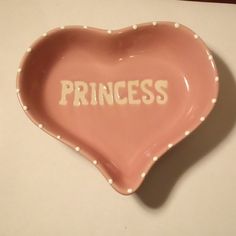 a pink heart shaped dish with the word princess written on it