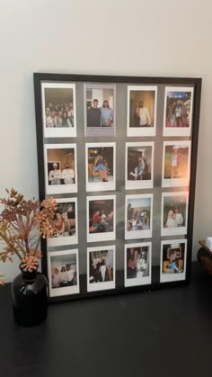 a black table topped with pictures and a vase filled with flowers