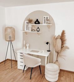 a white desk and chair in a room with wood flooring, shelves on the wall