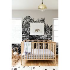 a baby's room with black and white wallpaper, a rocking chair, and a wooden crib